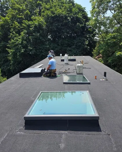 Flat roof skylights installed with surrounding roofing work